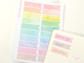 Pastel color watercolor flags sticker sheet and a notebook with stickers on a light background.